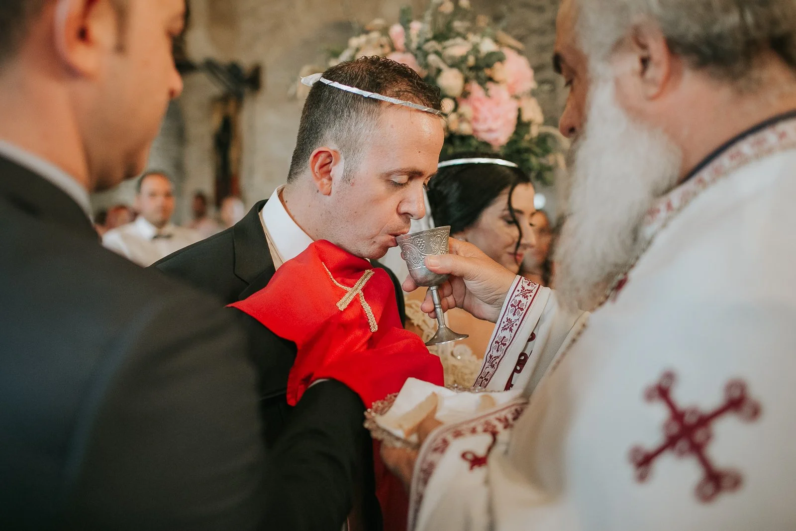  Greek Orthodox wedding ceremony as the groom receives Holy Communion from the priest during the service. 