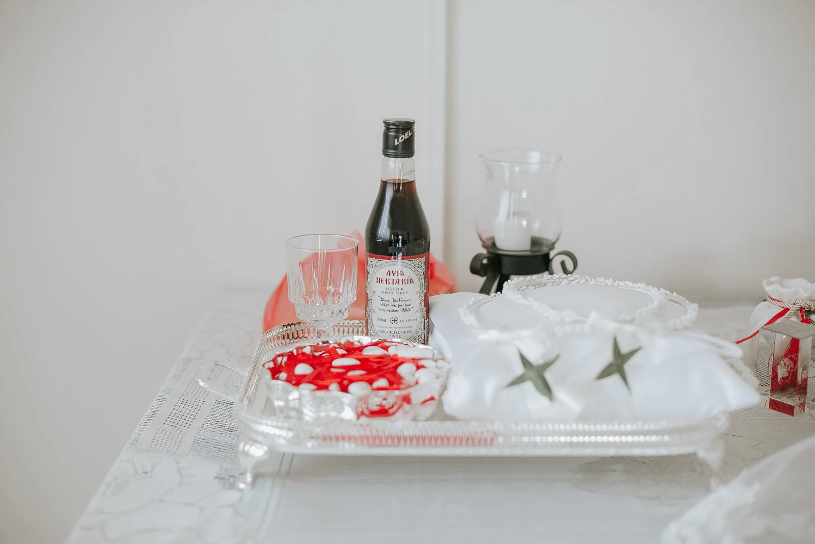  Traditional Greek Orthodox wedding ceremony details including stefana crowns, koufeta almonds, ceremonial wine and wedding rings prepared for the sacrament of marriage. 