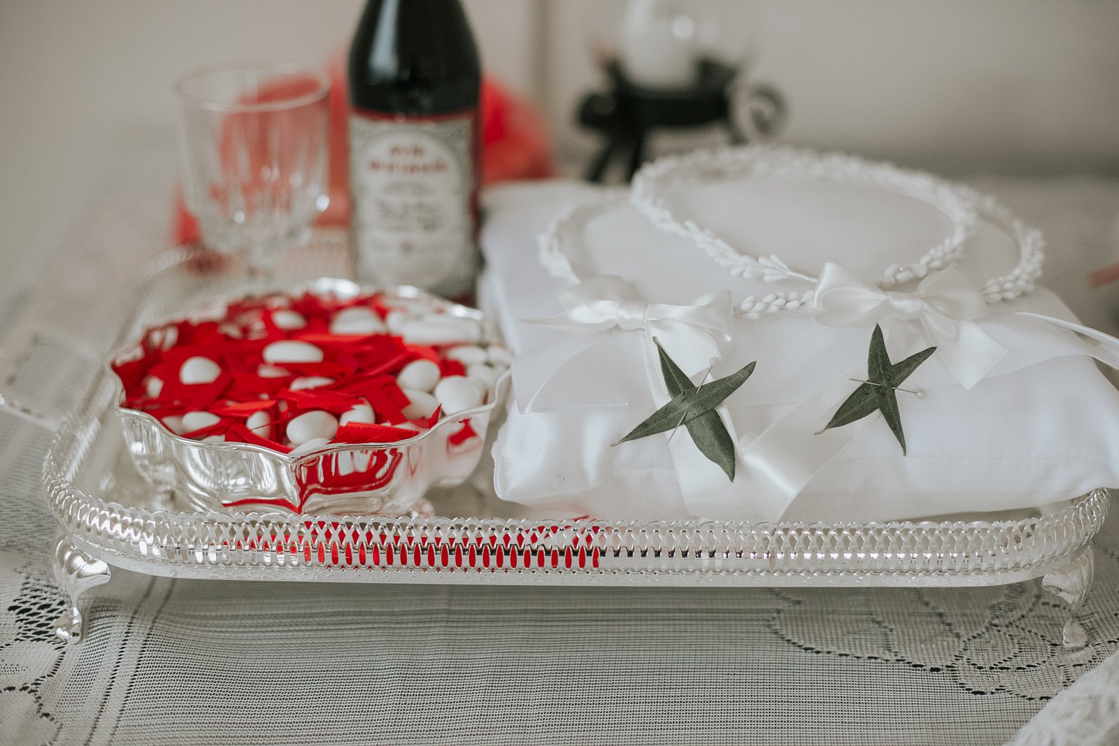  Traditional Greek Orthodox wedding ceremony details including stefana crowns, koufeta almonds, ceremonial wine and wedding rings prepared for the sacrament of marriage. 