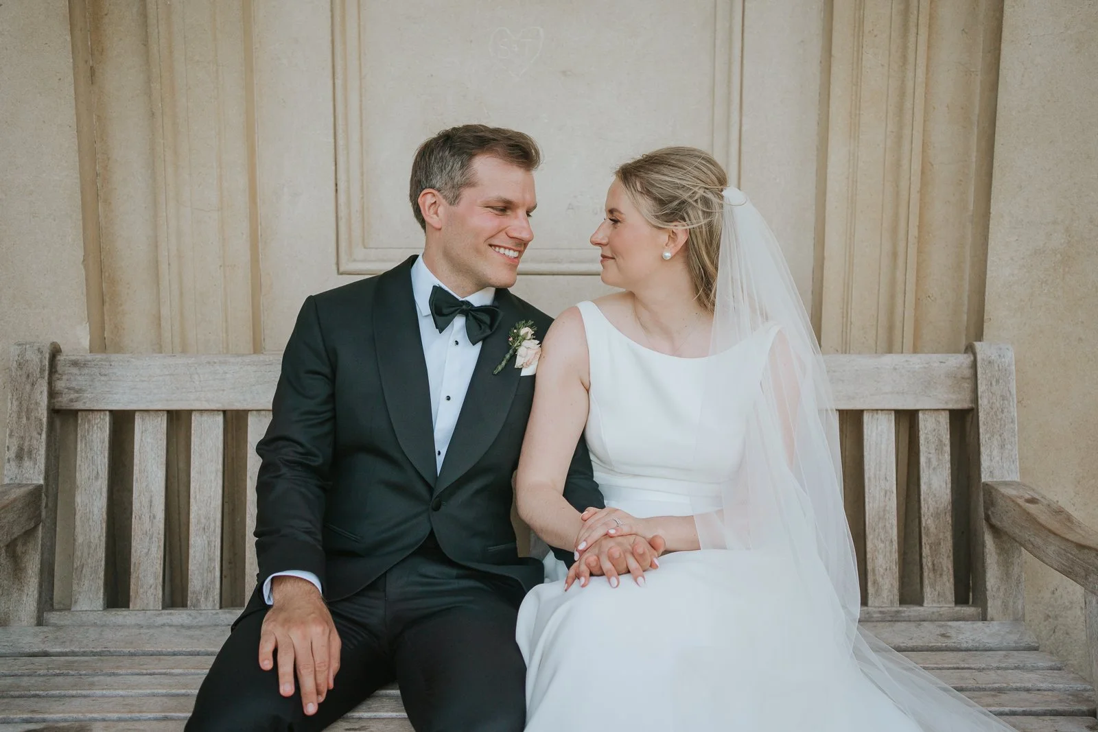  Newlyweds sharing a quiet moment on a bench inside King William’s Temple at Kew Gardens, photographed in a natural documentary wedding style.   