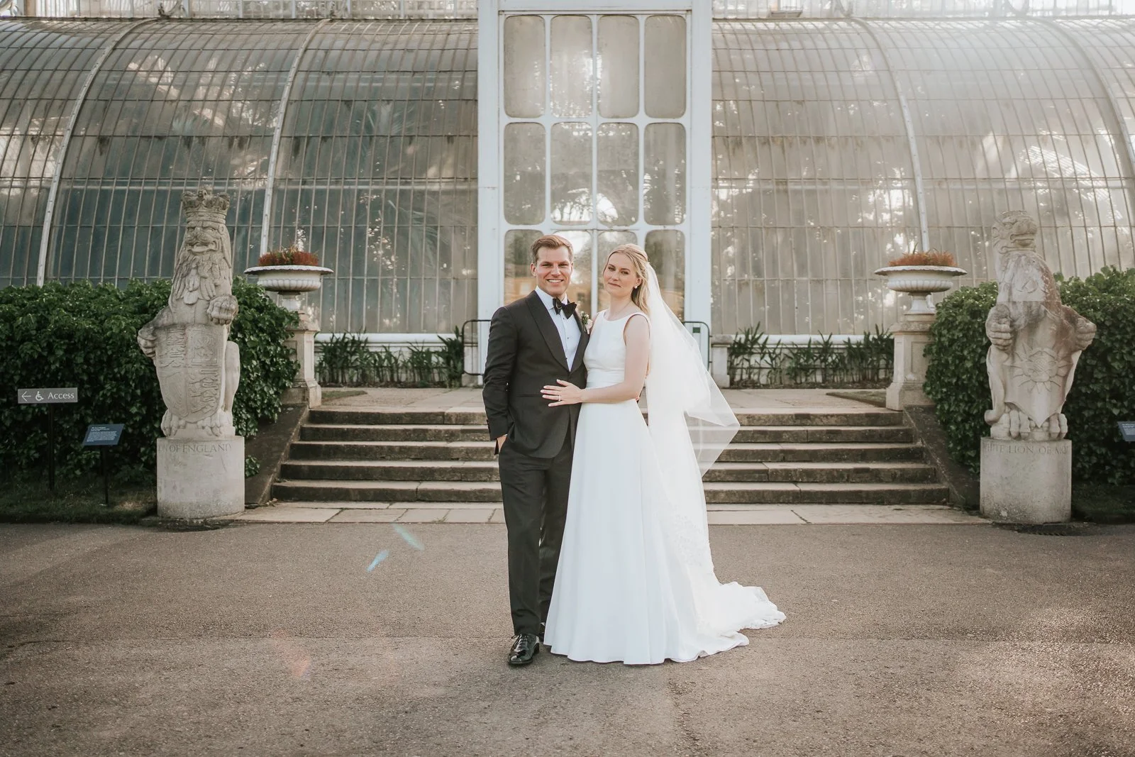  Elegant bride and groom portrait outside The Palm House at Kew Gardens, showcasing the grandeur of the historic conservatory. 