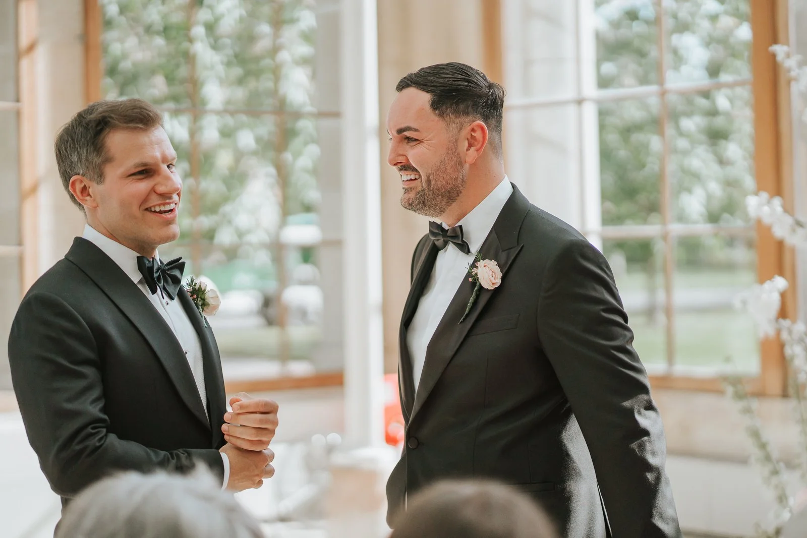  Groom and best man sharing a laugh in the light-filled Nash Conservatory at Kew Gardens before the wedding ceremony. 