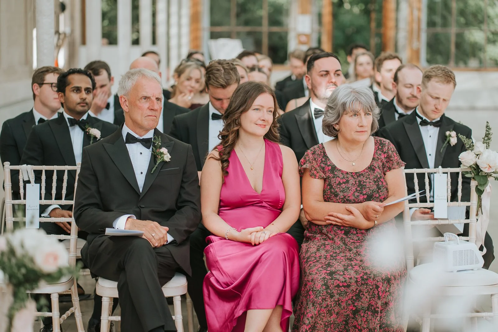  Family members listening attentively during a wedding ceremony at the Nash Conservatory, Kew Gardens. 