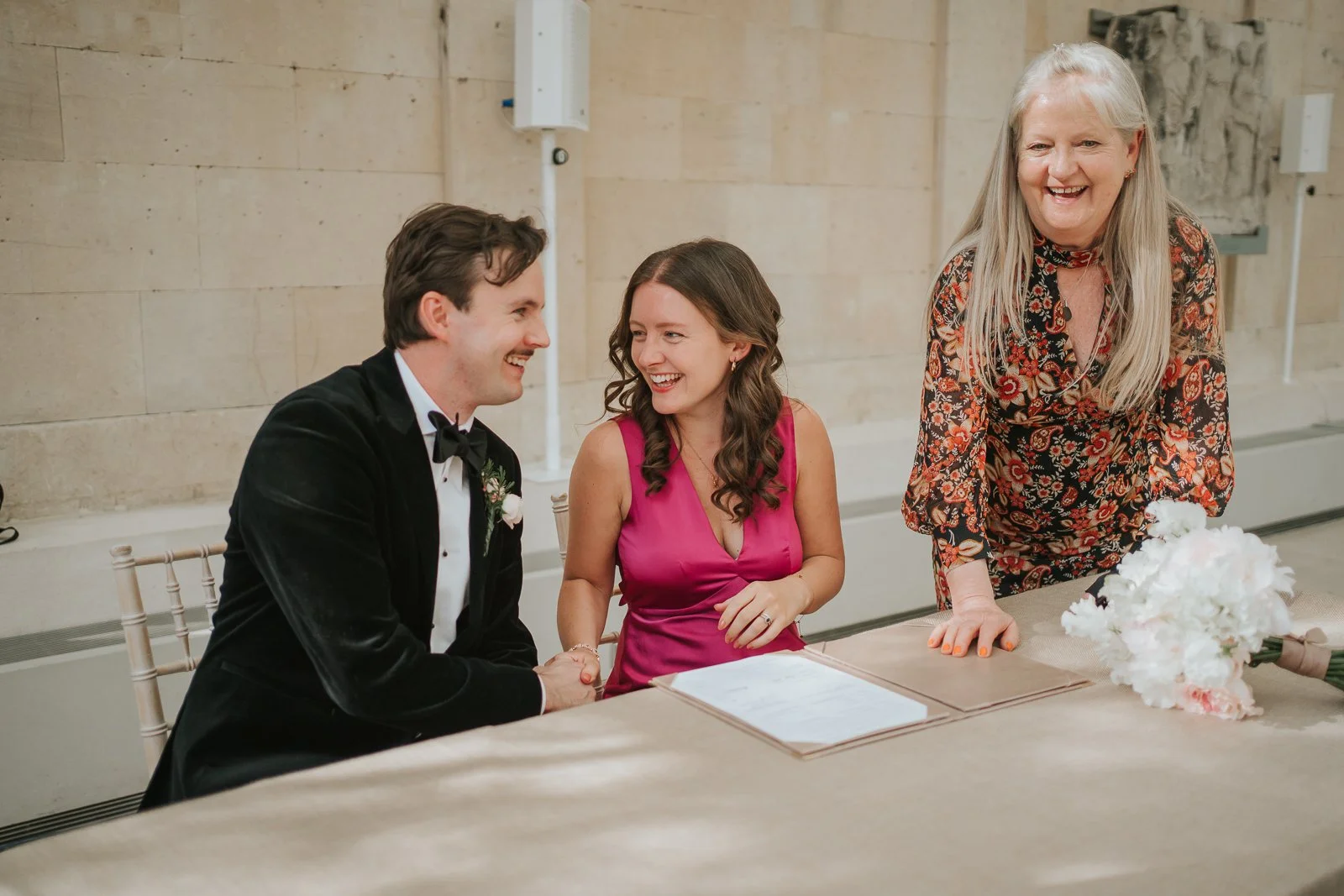  Witnesses sharing a joyful moment during the wedding ceremony at the Nash Conservatory in Kew Gardens. 
