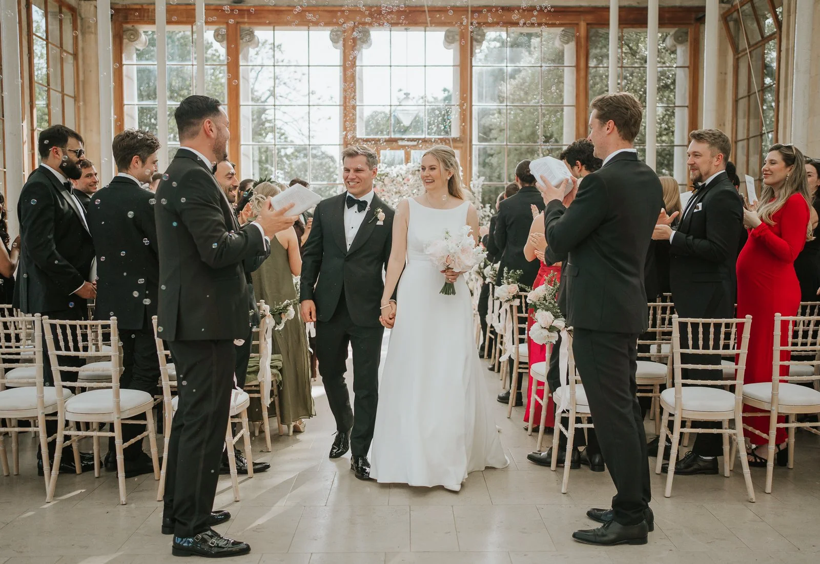  Newlyweds walking back down the aisle through bubbles and applause after their wedding ceremony at the Nash Conservatory. 