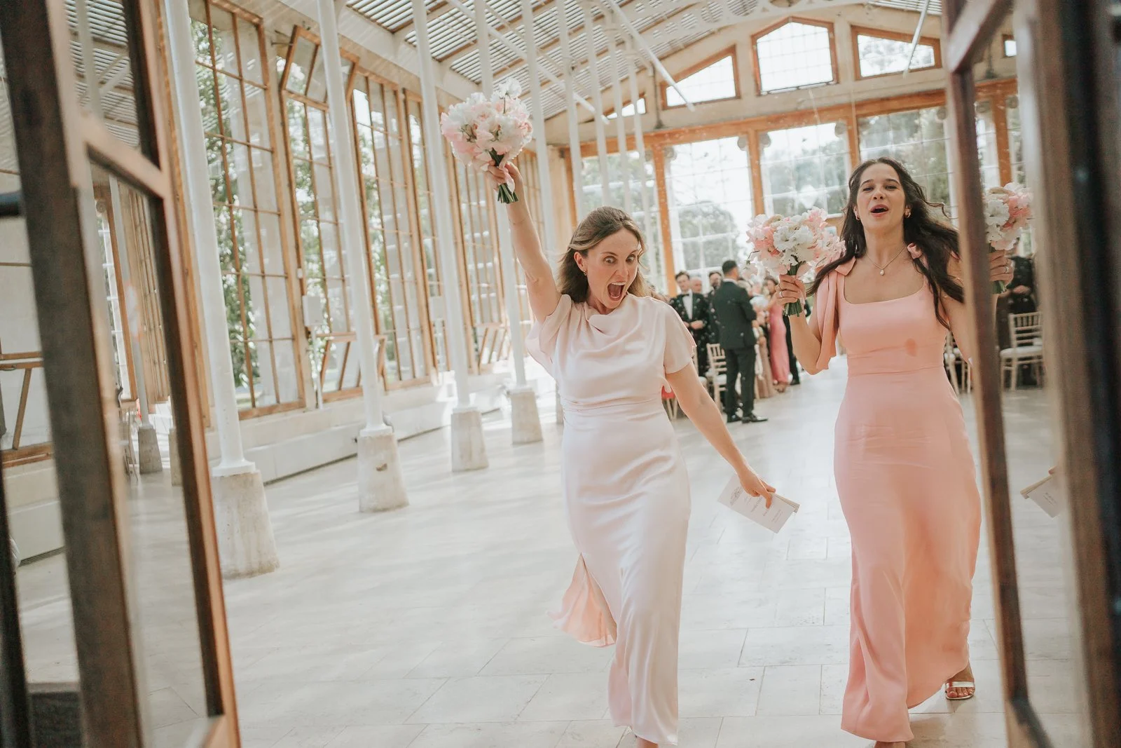  Bridesmaids celebrating with bouquets inside the Nash Conservatory at Kew Gardens following the wedding ceremony. 