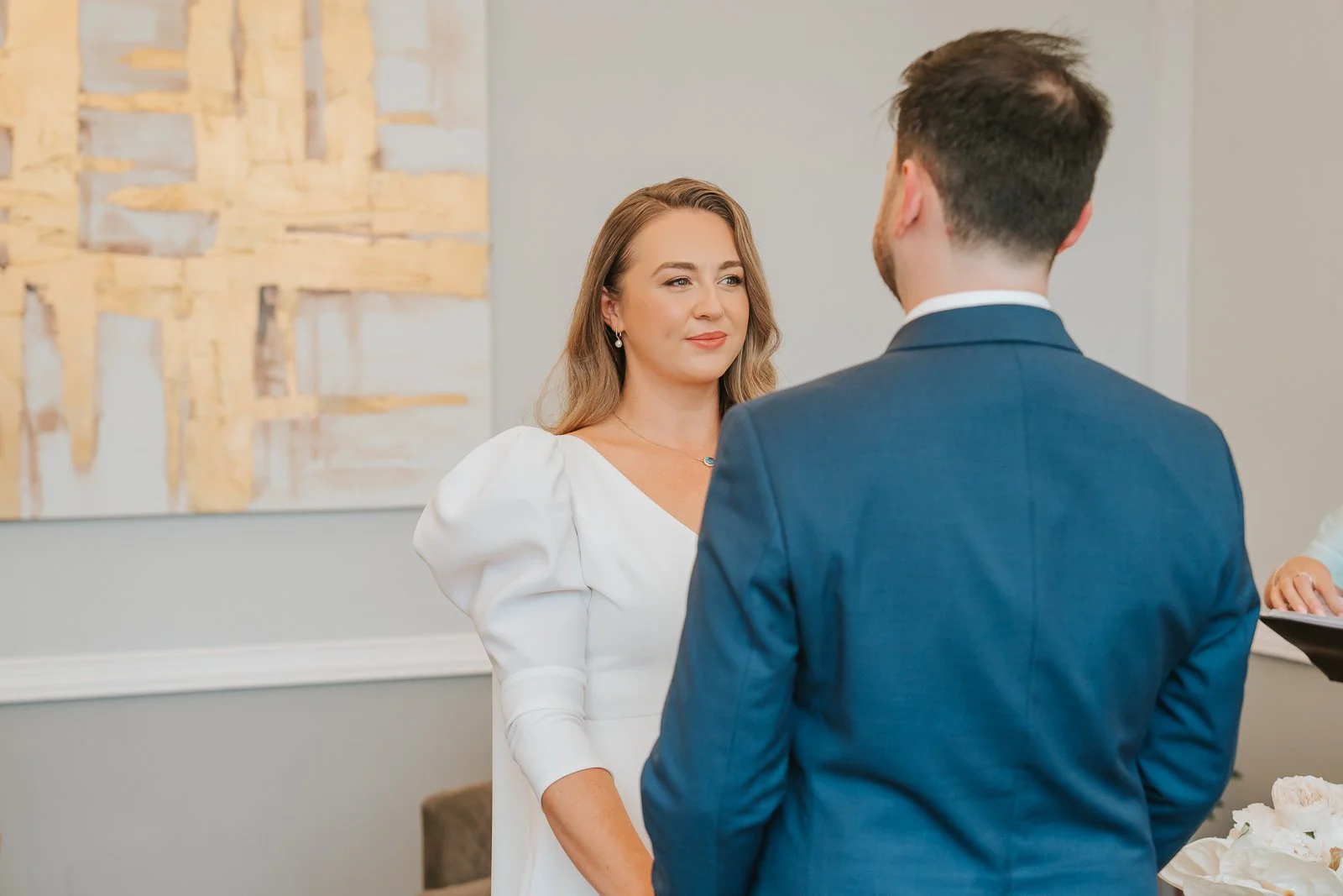  Bride and groom exchange vows during a civil wedding ceremony in Room 99 at Islington Town Hall. 