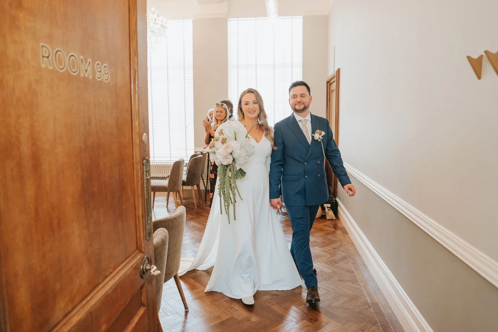  Bride and groom leaving Room 99 at Islington Town Hall following their intimate London wedding ceremony. 