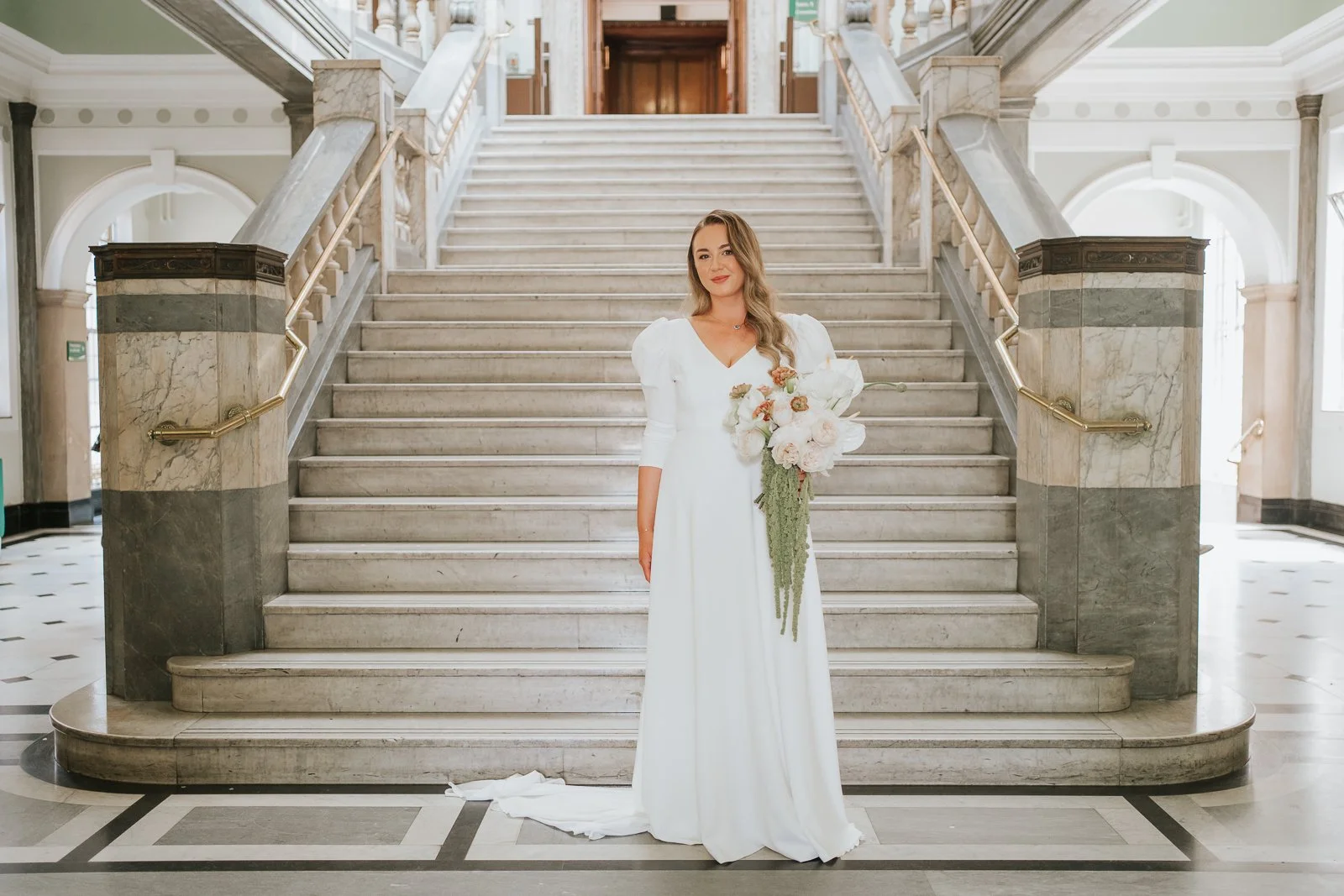  Bridal portrait on the marble staircase at Islington Town Hall with elegant wedding flowers and natural light. 