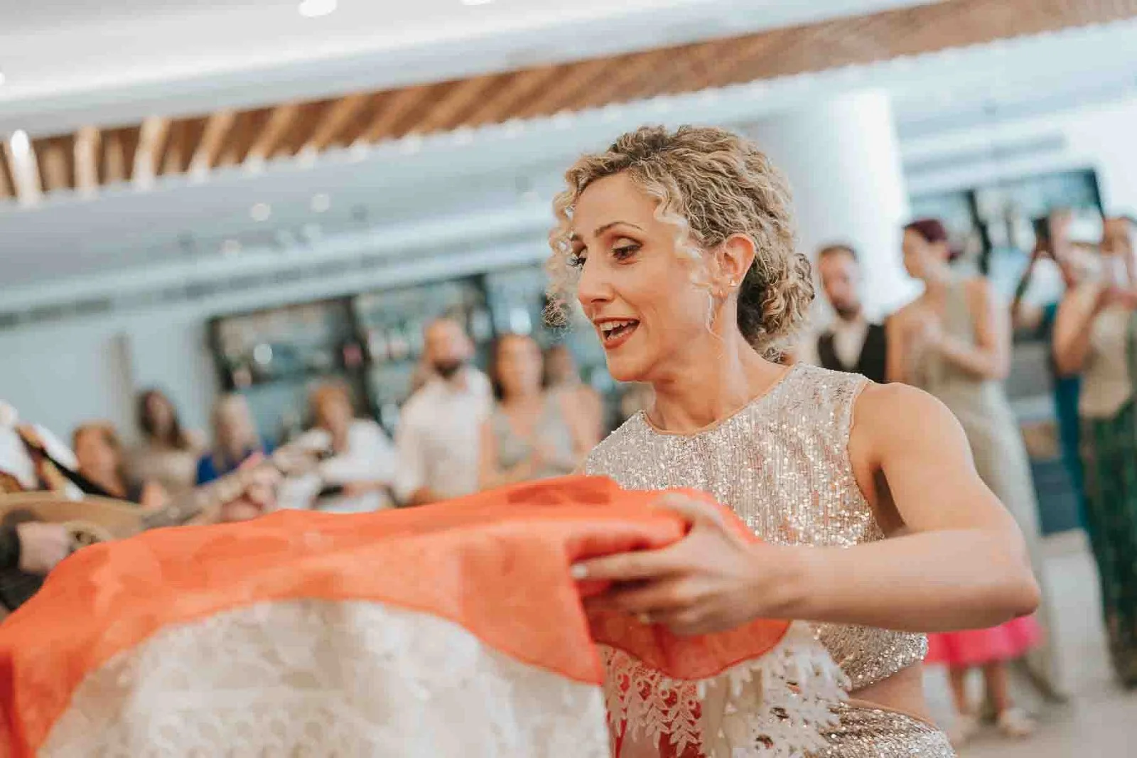 Wedding guest dancing with a scarf during a traditional Greek wedding celebration, accompanied by live musicians and enthusiastic guests. 