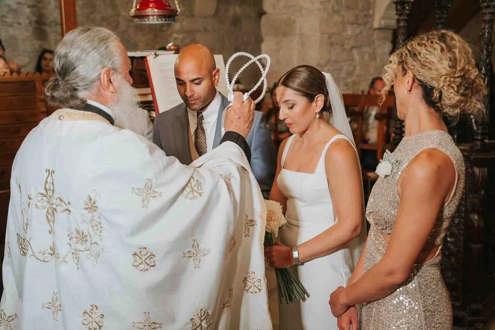  Priest holding the stefana crowns above the bride and groom during a traditional Greek Orthodox wedding ceremony in London. 