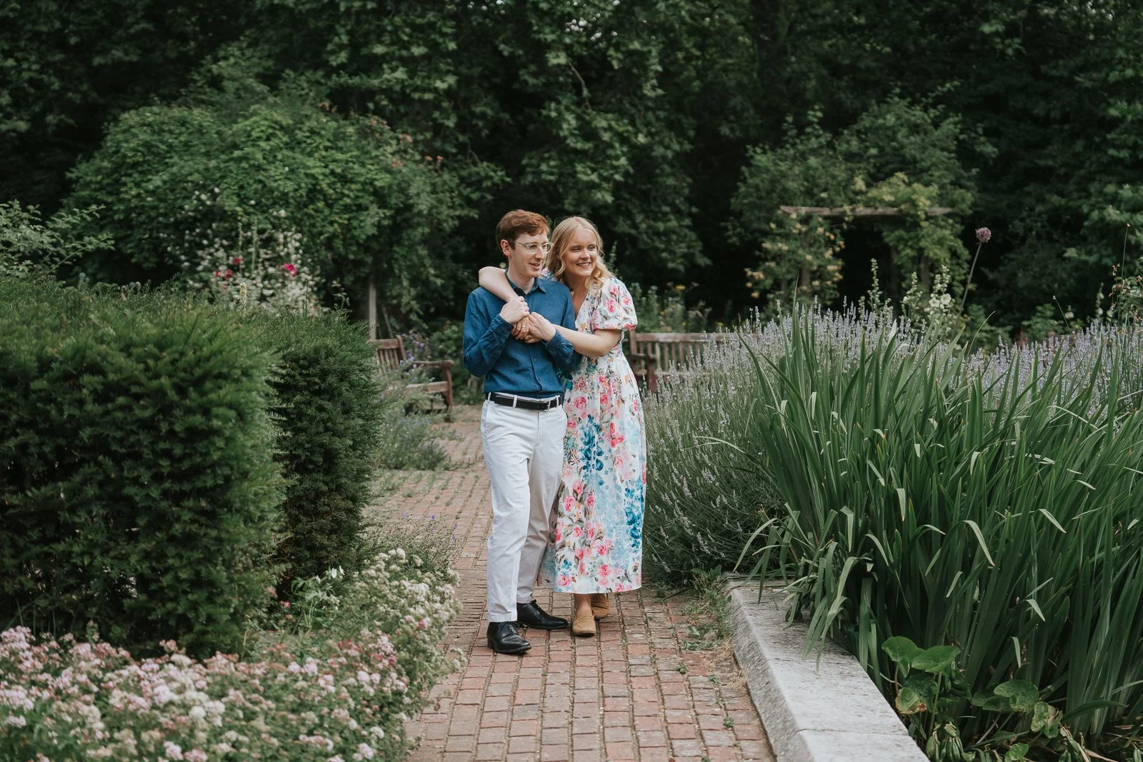 Relaxed engagement photography in Battersea Park, London, with a couple walking arm in arm through the park's colourful summer gardens. 