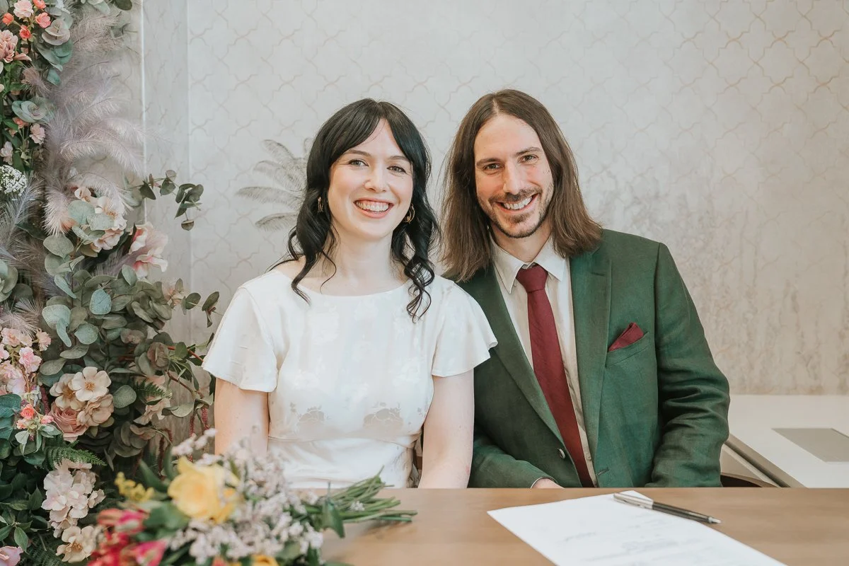  Happy newlyweds signing the marriage register in the  Pauline Room at Lambeth Town Hall  following their intimate London wedding ceremony. 
