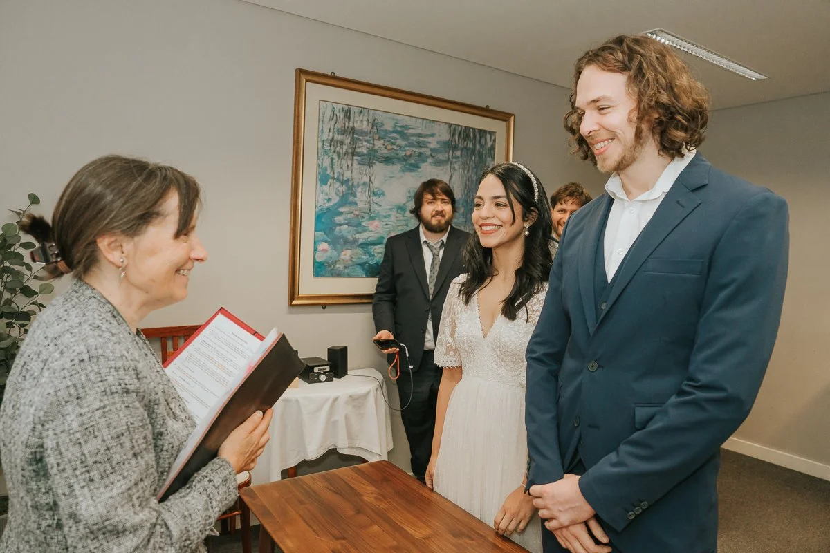  Bride and groom listening to the registrar during a relaxed civil wedding ceremony at Kingston Register Office. 