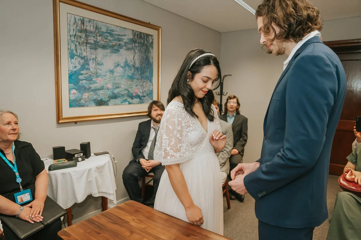  Bride and groom exchanging vows and rings during a romantic wedding ceremony at Kingston Register Office. 