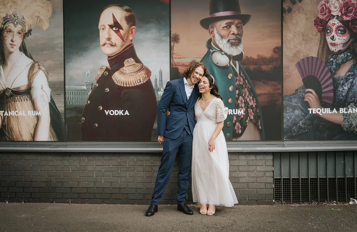  Bride and groom sharing a quiet moment in front of Kingston's vibrant mural wall after their intimate civil wedding ceremony. 