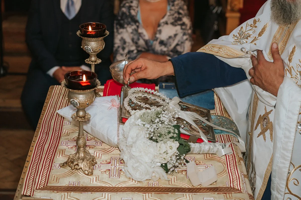  Traditional Greek Orthodox wedding crowns, candles and bridal bouquet during a ceremony at Saint Nectarios Church, Battersea. 