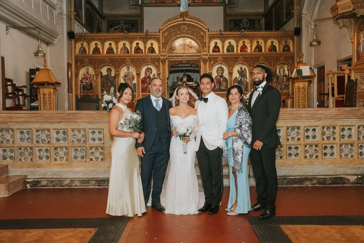  Bride and groom with close family inside Saint Nectarios Greek Orthodox Church in Battersea after their wedding ceremony. 