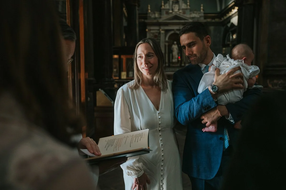   Parents holding their baby during a christening ceremony at Brompton Oratory in London.  