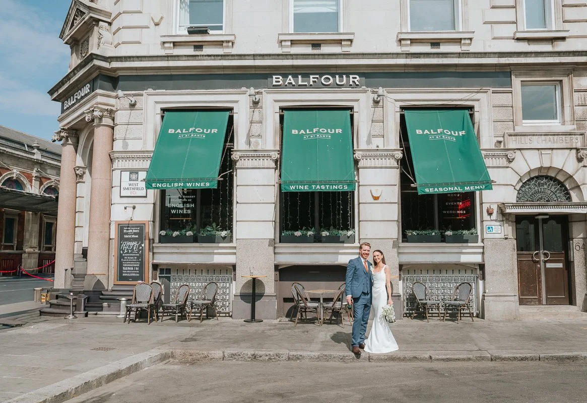  Couple outside Balfour St Barts in Smithfield, London, after their wedding, with the venue’s distinctive green awnings behind them. 