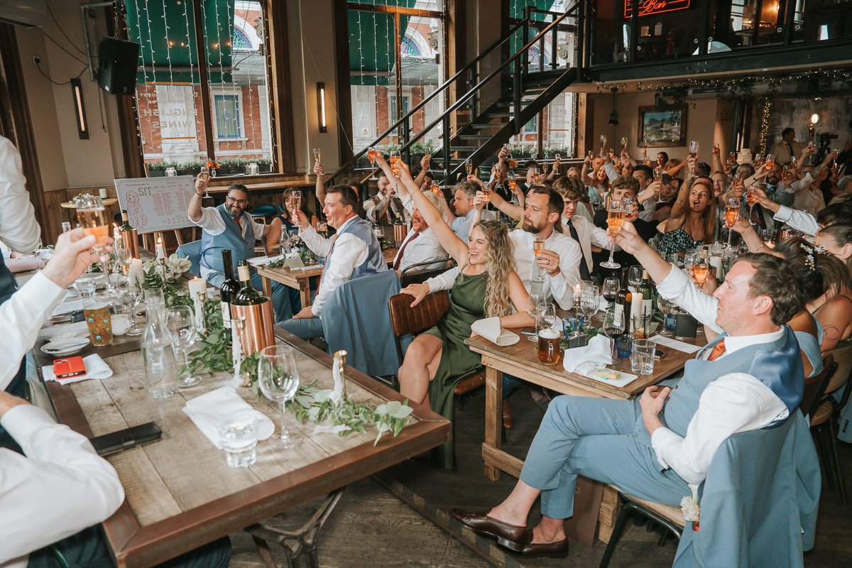  Wedding guests raising their glasses for a toast during speeches at Balfour St Barts in London. 