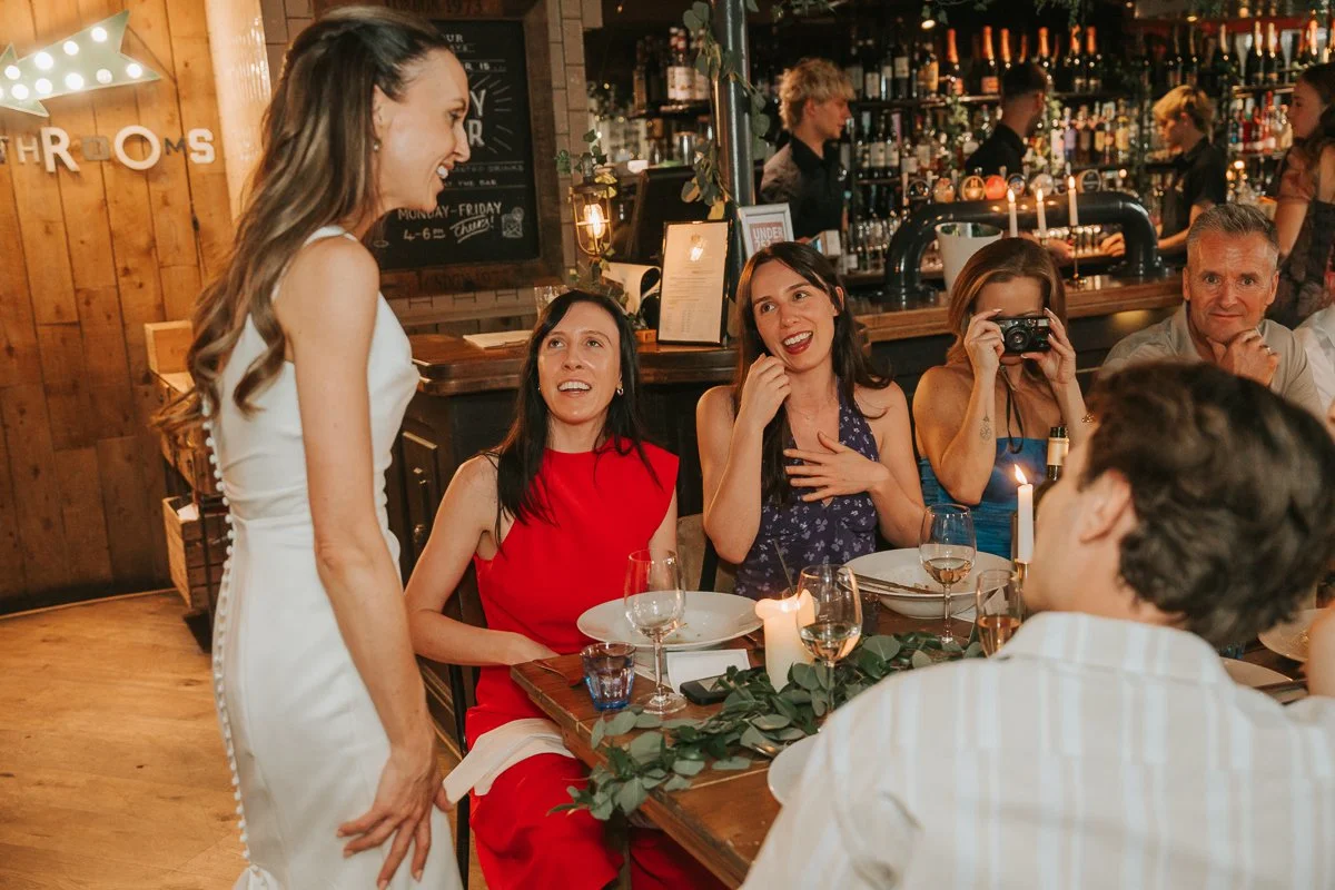 Bride laughing with friends during her relaxed wedding reception at Balfour St Barts in Smithfield. 
