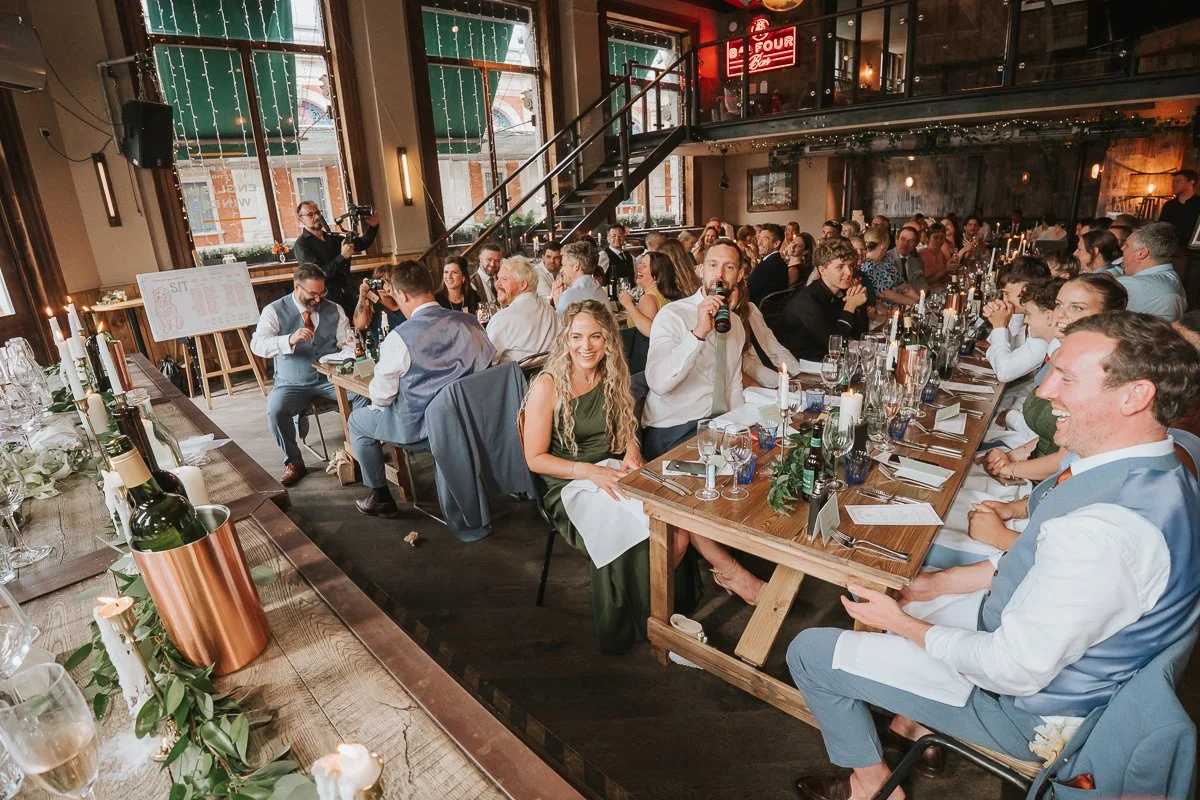 Wedding guests enjoying the speeches inside the characterful Balfour St Barts wedding venue in London. 