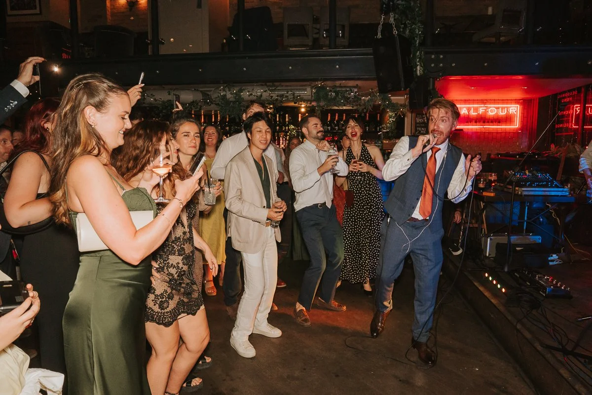 Groom singing on the dance floor surrounded by guests at his Balfour St Barts wedding reception. 