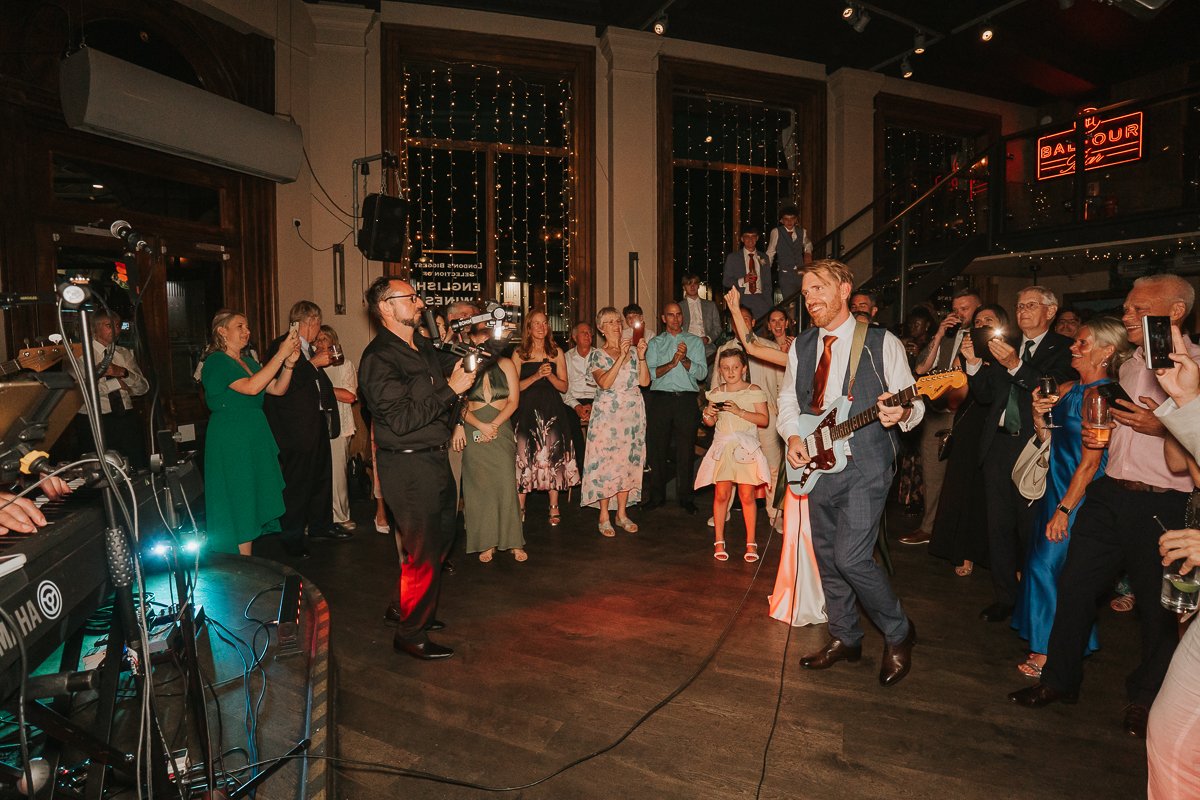  Groom playing guitar with the live wedding band at Balfour St Barts in Smithfield. 