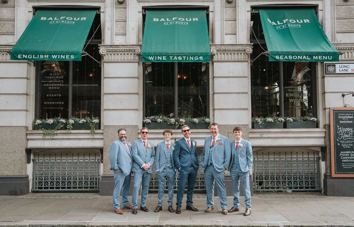  Groom with his groomsmen beneath the green awnings outside Balfour St Barts wedding venue in Smithfield. 