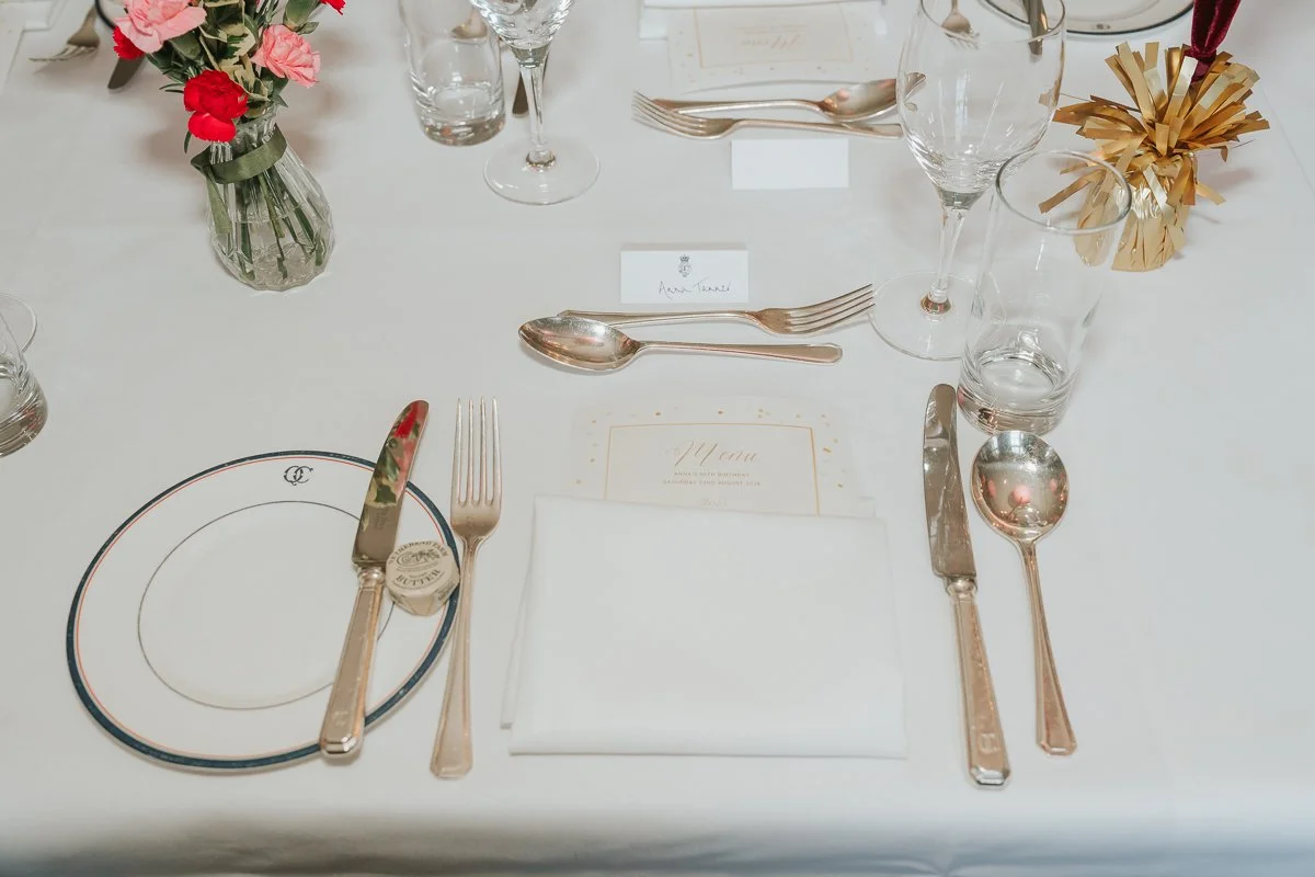  Elegant place setting with flowers and a personalised menu for a 30th birthday dinner at The Queen’s Club. 