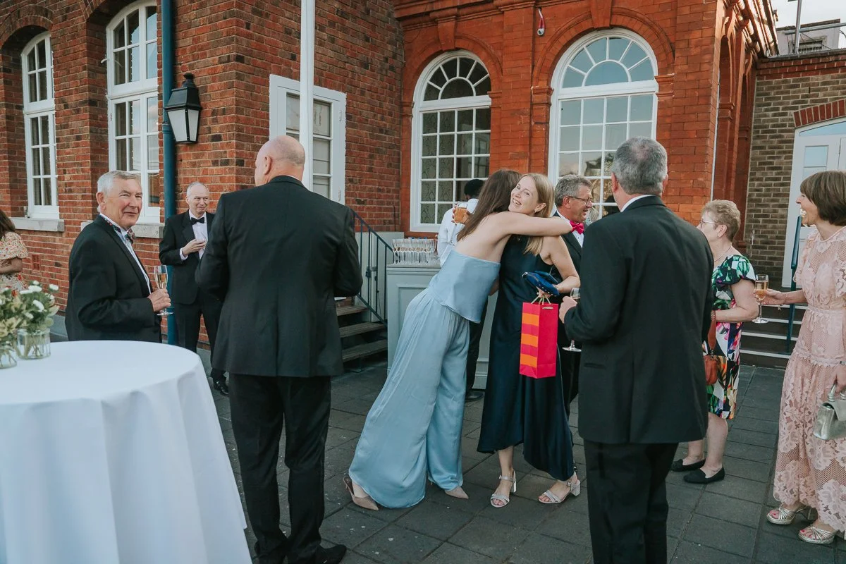  Friends greeting each other during a 30th birthday celebration on The Queen’s Club terrace. 