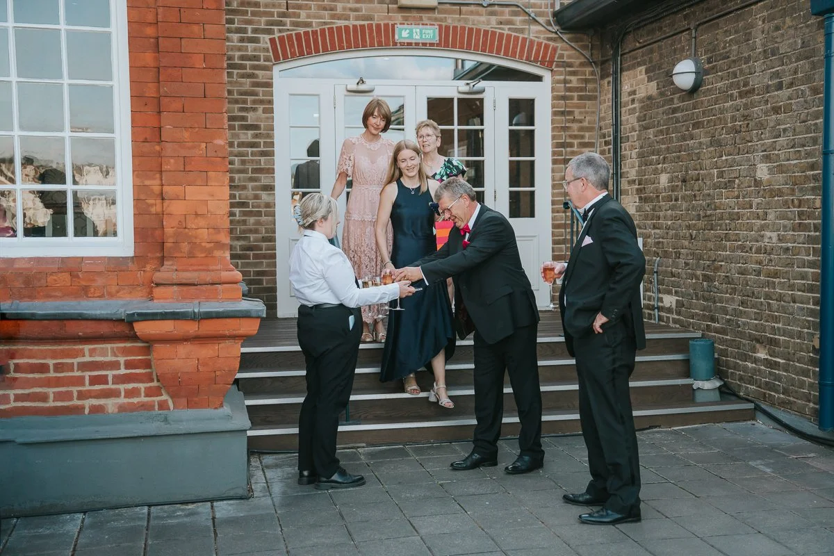  Birthday party guests arriving for an outdoor drinks reception on the terrace at The Queen’s Club in London. 