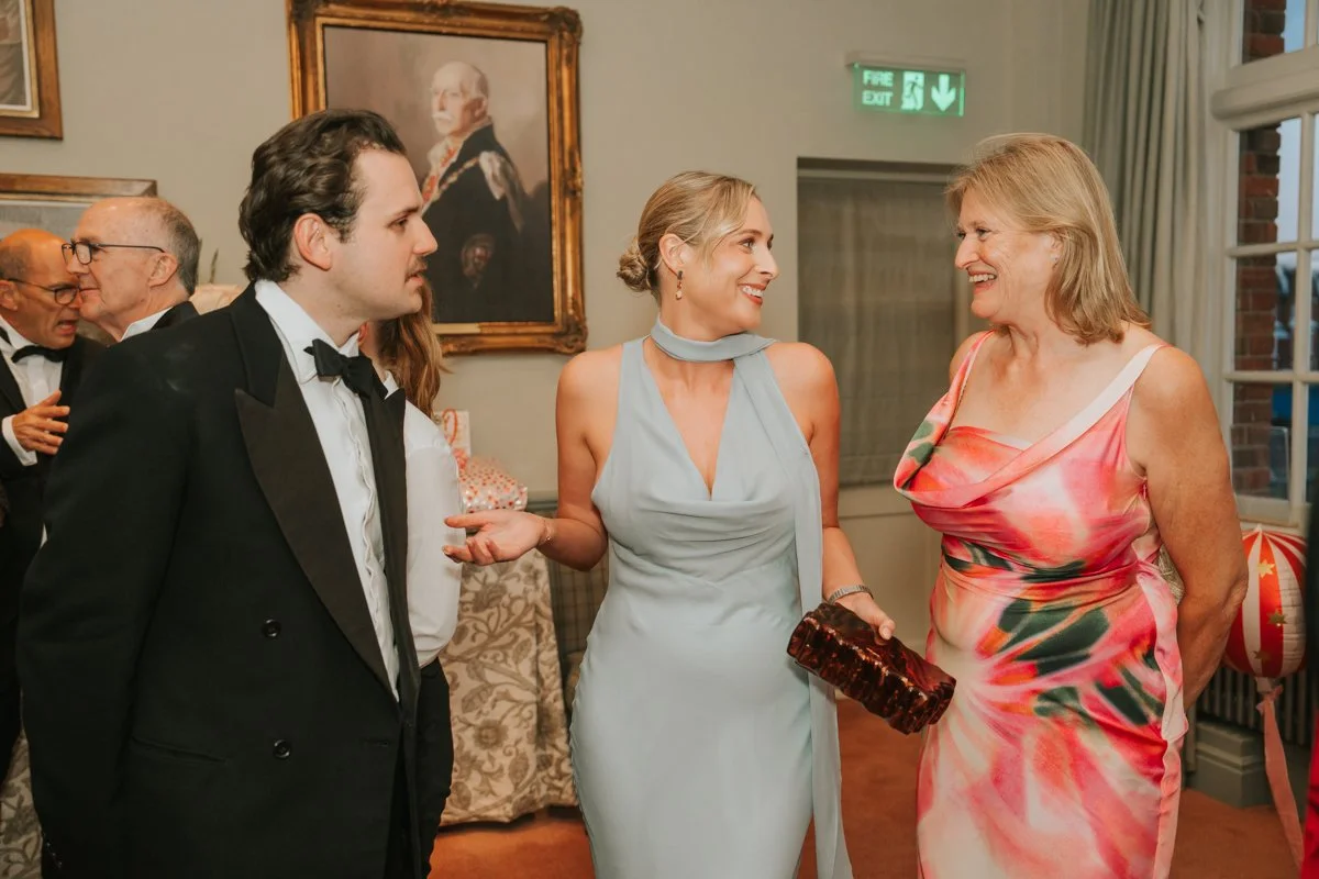  Friends enjoying a relaxed conversation during a 30th birthday party at The Queen’s Club. 