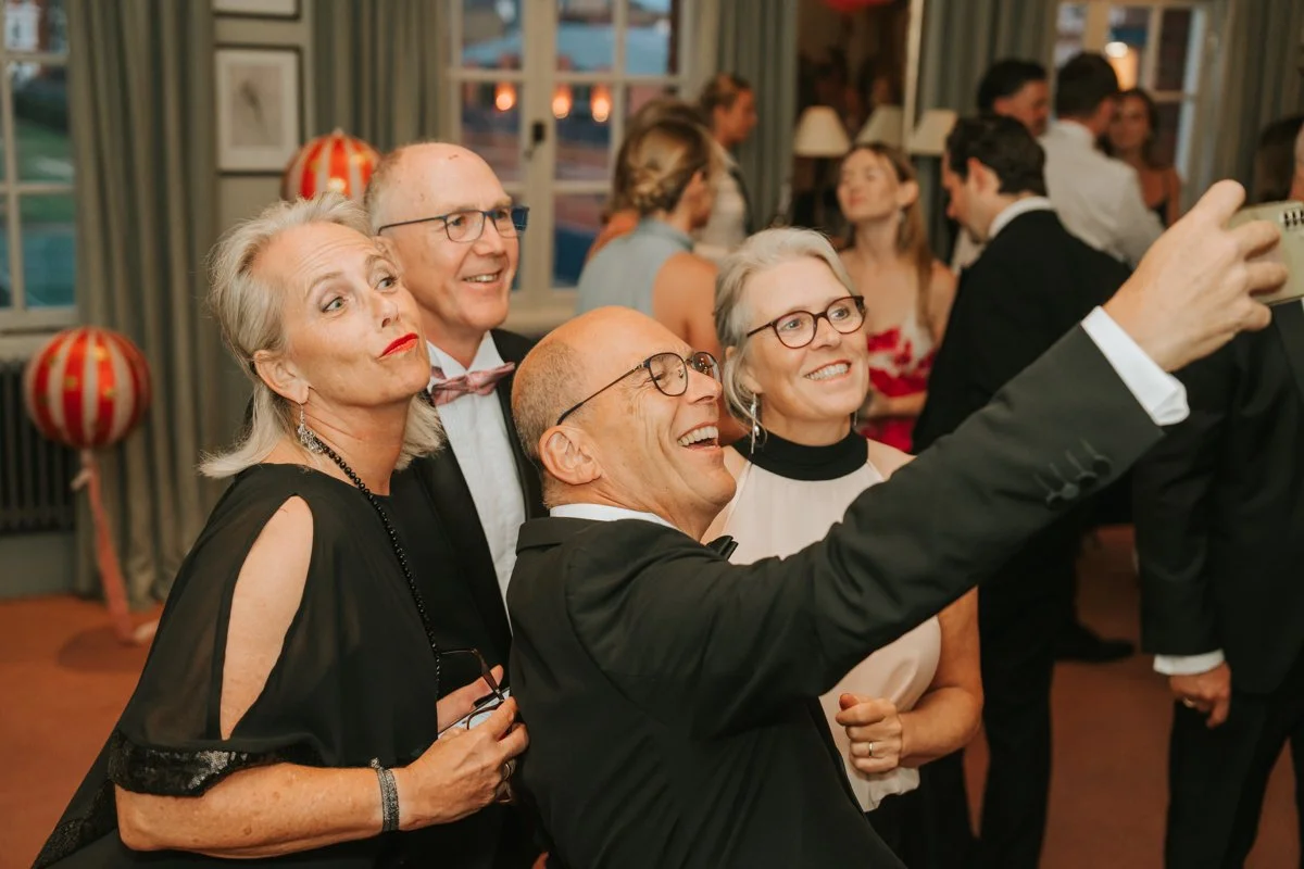  Guests chatting and taking a group selfie during a 30th birthday party at The Queen’s Club in London. 