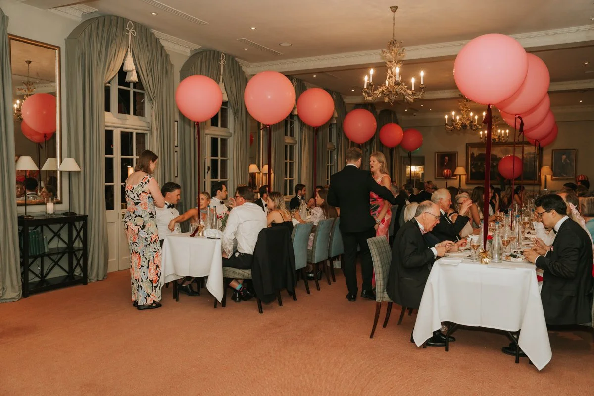  Guests dining beneath pink balloon decorations during a private 30th birthday celebration at The Queen’s Club. 