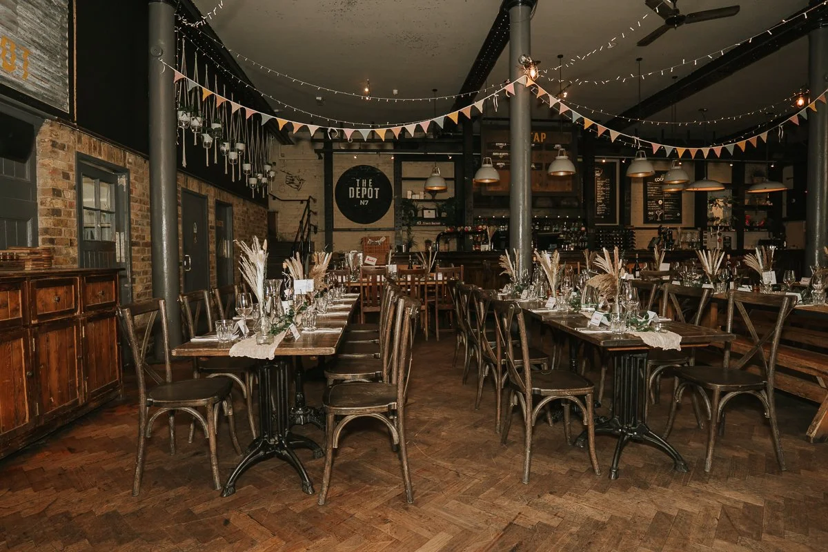  Wedding reception tables set for guests inside the industrial-style Depot wedding venue in Islington, London. 