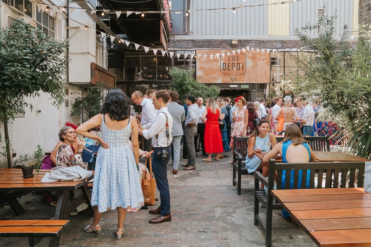  The Depot Islington courtyard filled with wedding guests enjoying drinks and celebrating after the ceremony. 