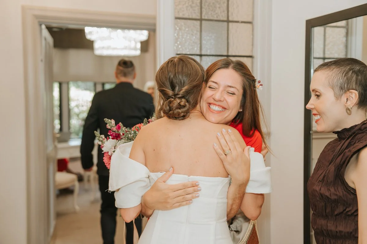   Bride greeting a wedding guest before her ceremony at Weybridge Register Office in Surrey.  