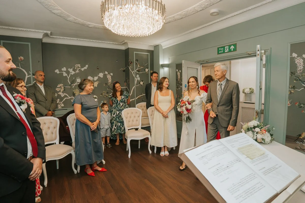  Bride entering with family and wedding guests during her ceremony at Weybridge Register Office in Surrey. 
