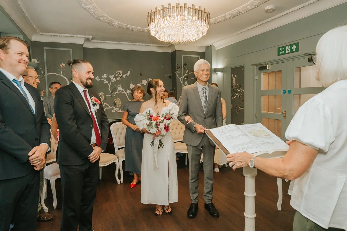  Weybridge Register Office wedding photography capturing the bride arriving with her father and smiling at the groom. 