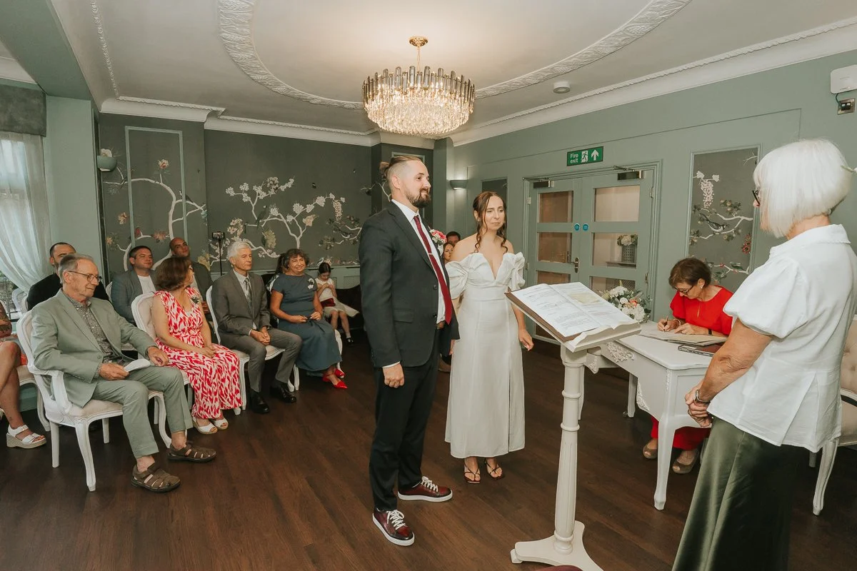 Bride and groom standing together during their intimate wedding ceremony at Weybridge Register Office in Surrey. 