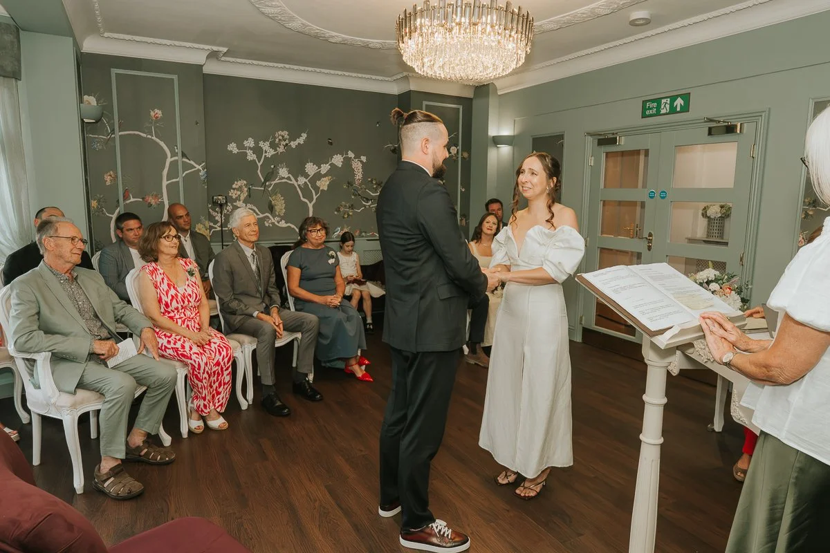  Natural wedding photography of the bride and groom smiling at each other during their Weybridge Register Office ceremony. 
