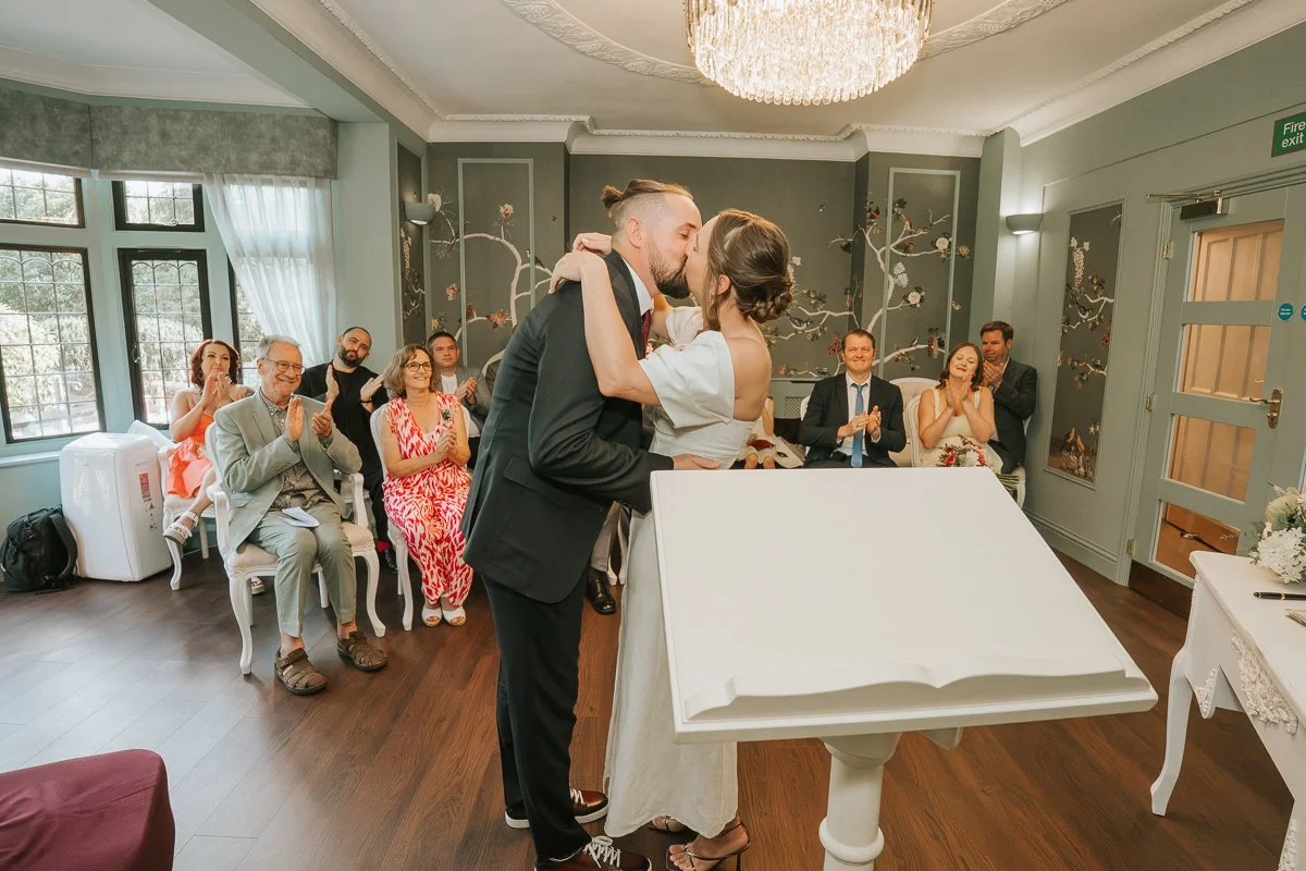  Newlyweds sharing their first kiss during their wedding ceremony at Weybridge Register Office. 