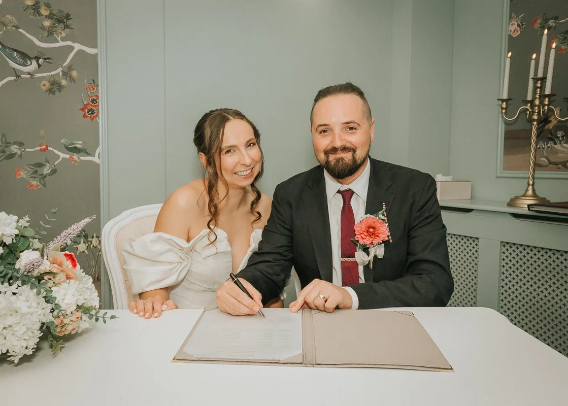  Newlyweds signing the marriage register together at Weybridge Register Office after their ceremony. 
