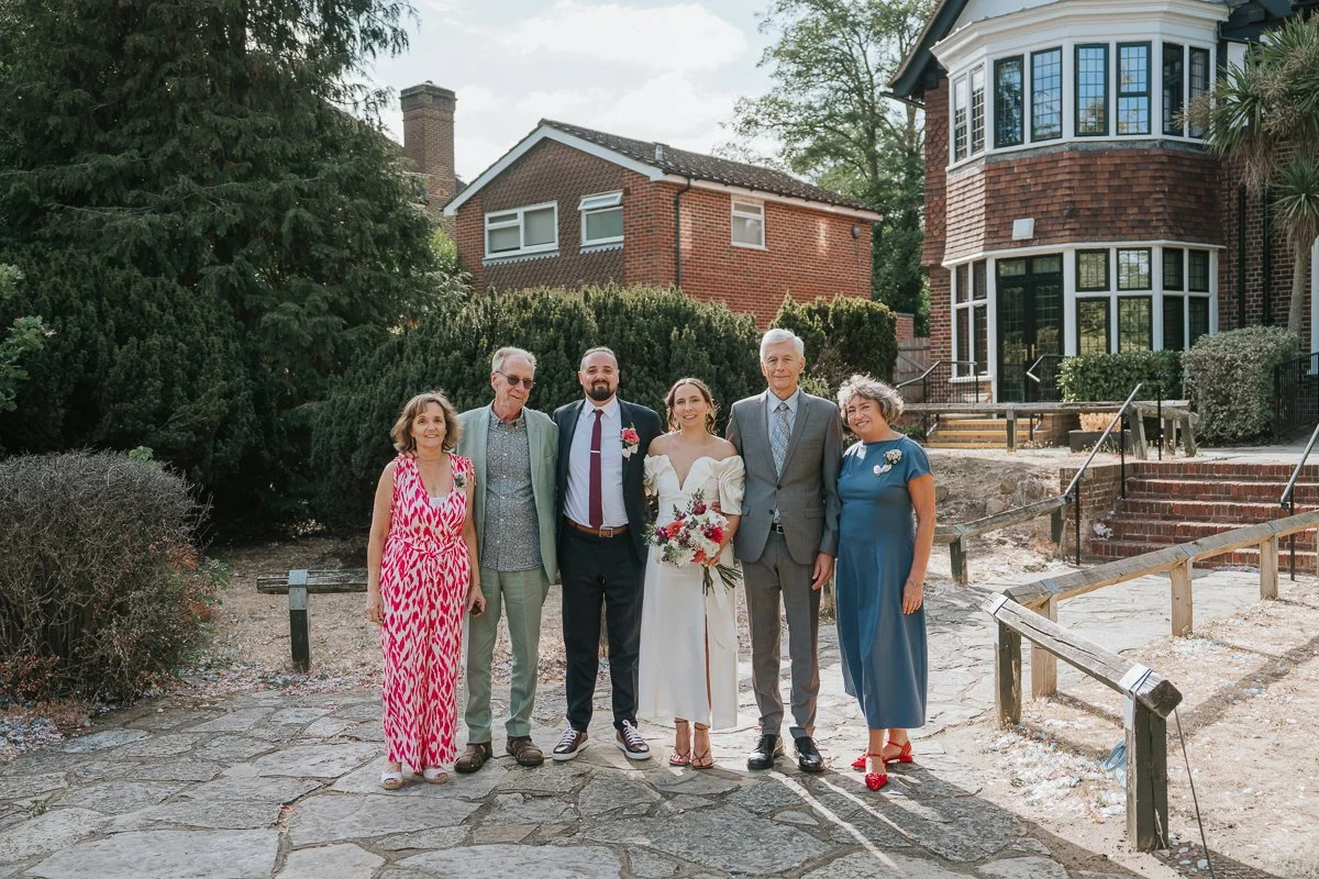  Weybridge Register Office wedding photography of the newlyweds with their family in the venue gardens. 