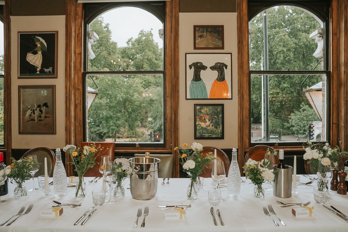  Wedding table setting in the Bridge Room at The Prince Albert, with flowers and views towards Battersea Park. 