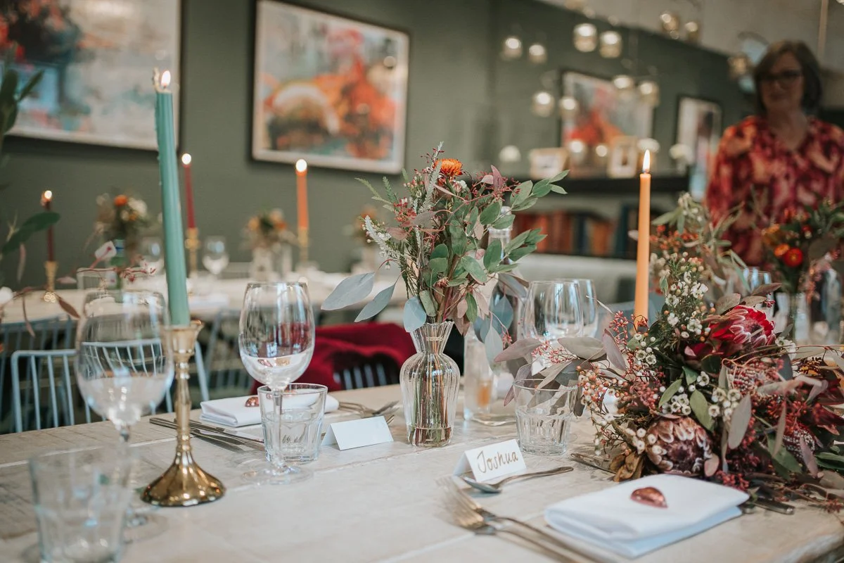  Colourful candles and flowers decorating a wedding reception table at The Phene in Chelsea. 
