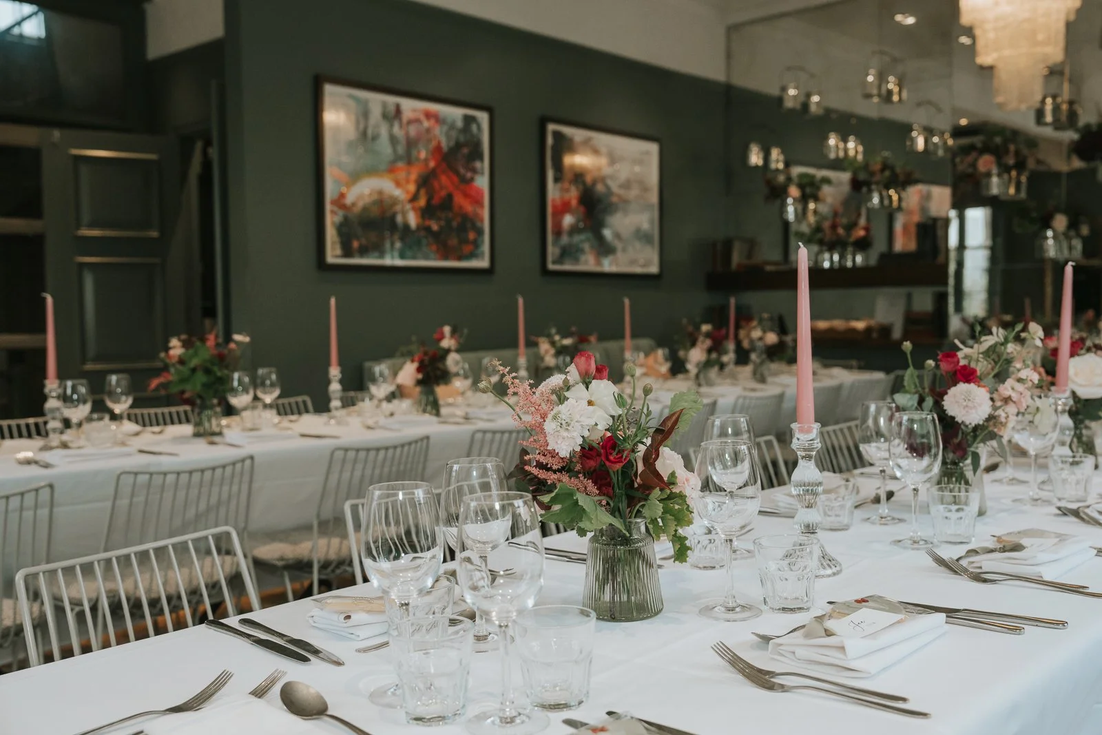  Wedding breakfast tables at The Phene in Chelsea, dressed with white tablecloths, pink candles and colourful floral centrepieces. 