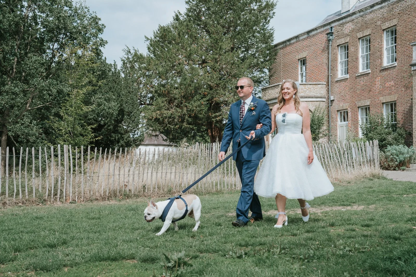  Newlyweds walking their dog across the lawn at Morden Park House. 